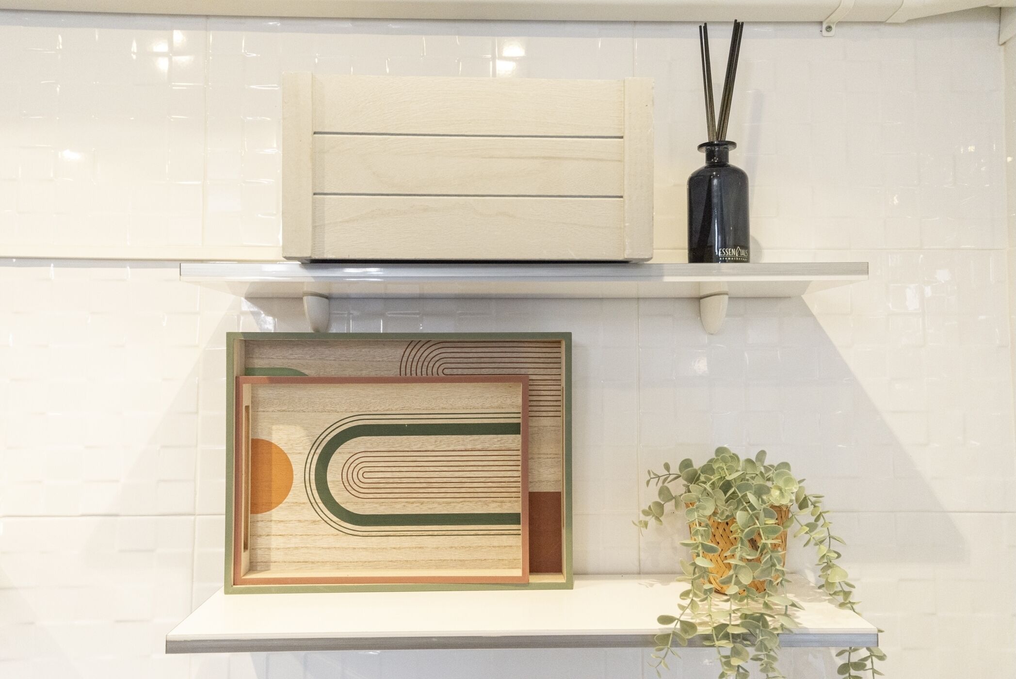 Una cocina con un mueble de madera, una obra de arte enmarcada, una botella negra y una planta en maceta.
