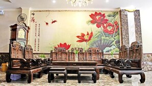 Ein traditioneller chinesischer Raum mit Holzmöbeln, einer großen Blumenmalerei und einem Chandelier.