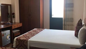 Un dormitorio con cama, cómoda, espejo y armario.