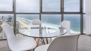 A modern room with a large window overlooking a beach and ocean.