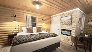 A cozy log cabin bedroom with a bed, bedside lamps, a stone fireplace, and a dining area. - Beaver Meadows Resort Ranch (Red Feather Lakes)