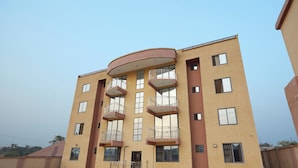 A multi-story building with balconies, large windows, and a flat roof. - Monroe Luxury Apartments (Kumasi)