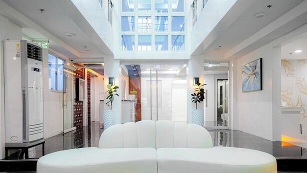 A modern interior with a central white sofa, glass ceiling, and minimalist decor. - Le Dream Hotel near Vigan (Vigan)