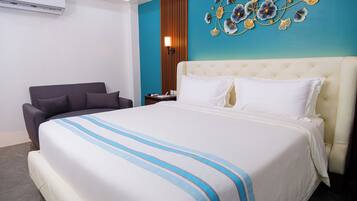 Une chambre d’hôtel avec un grand lit, une chaise, une table de chevet et un élément décoratif mural.