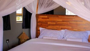 A bed with a wooden headboard and white bedding, under a canopy. - Amanya Hut Sleeps 6 with Mountain Views (Risa Amboseli National Park)