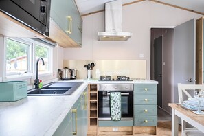 A modern kitchen with a built-in oven, a sink, and a window.