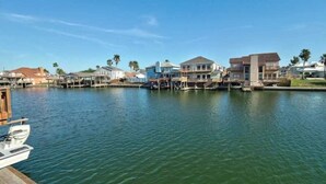 A waterfront property with docked boats, a marina, and residential buildings. - Relaxing Waterfront Home on Laguna Madre- Near Beach with Kayaking and Nature (Corpus Christi)