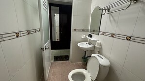 Un baño pequeño con inodoro, lavamanos y espejo.