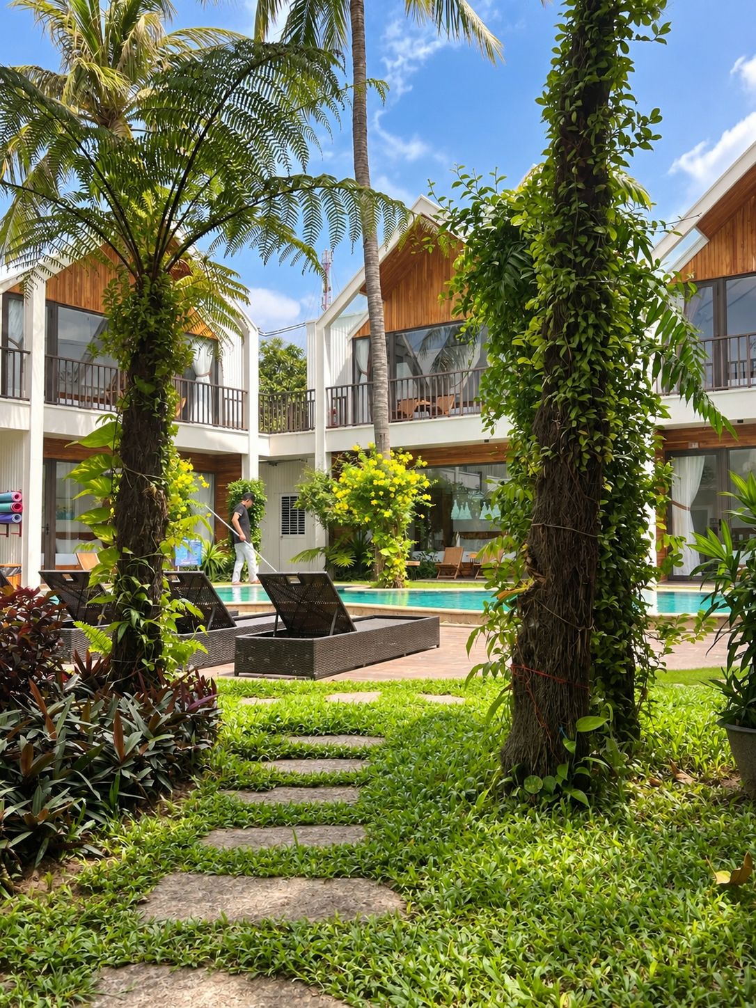 Ein Resort mit Pool, Liegestühlen und einem gepflegten Garten.