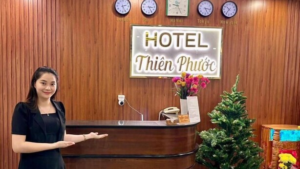 A hotel reception desk with clocks displaying times from London, Paris, Ha Noi, Tokyo, and New York. - Thien Phuoc Hotel - by Bay Luxury (Ho Chi Minh City)
