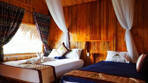 A wooden cabin room with two beds, each with white bedding and decorative pillows, and a large window with patterned curtains. - MONG NGUA BUNGALOW & HOMESTAY (Thong Nguyen)