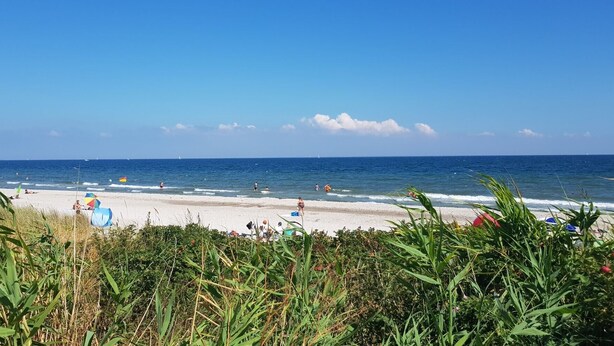 A beach with people, a flag, and a clear sky. - Apartment 'Haloi' with Private Terrace, Private Garden and Wi-Fi (Mittelangeln-Torsballig)