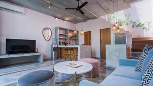 A modern living room with a flat-screen TV, a coffee table, and a sofa. - Liminal Palace Villa 1 by Betterplace (Canggu)