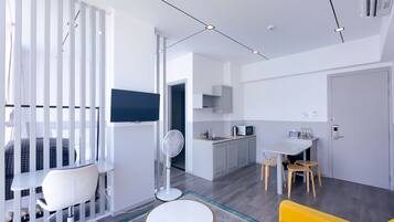 Una sala de estar moderna con sofá, comedor y cocina.