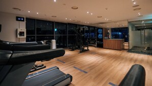 A modern gym with exercise equipment, a reception desk, and large windows. - HOMES Stay Suwon (Suwon)
