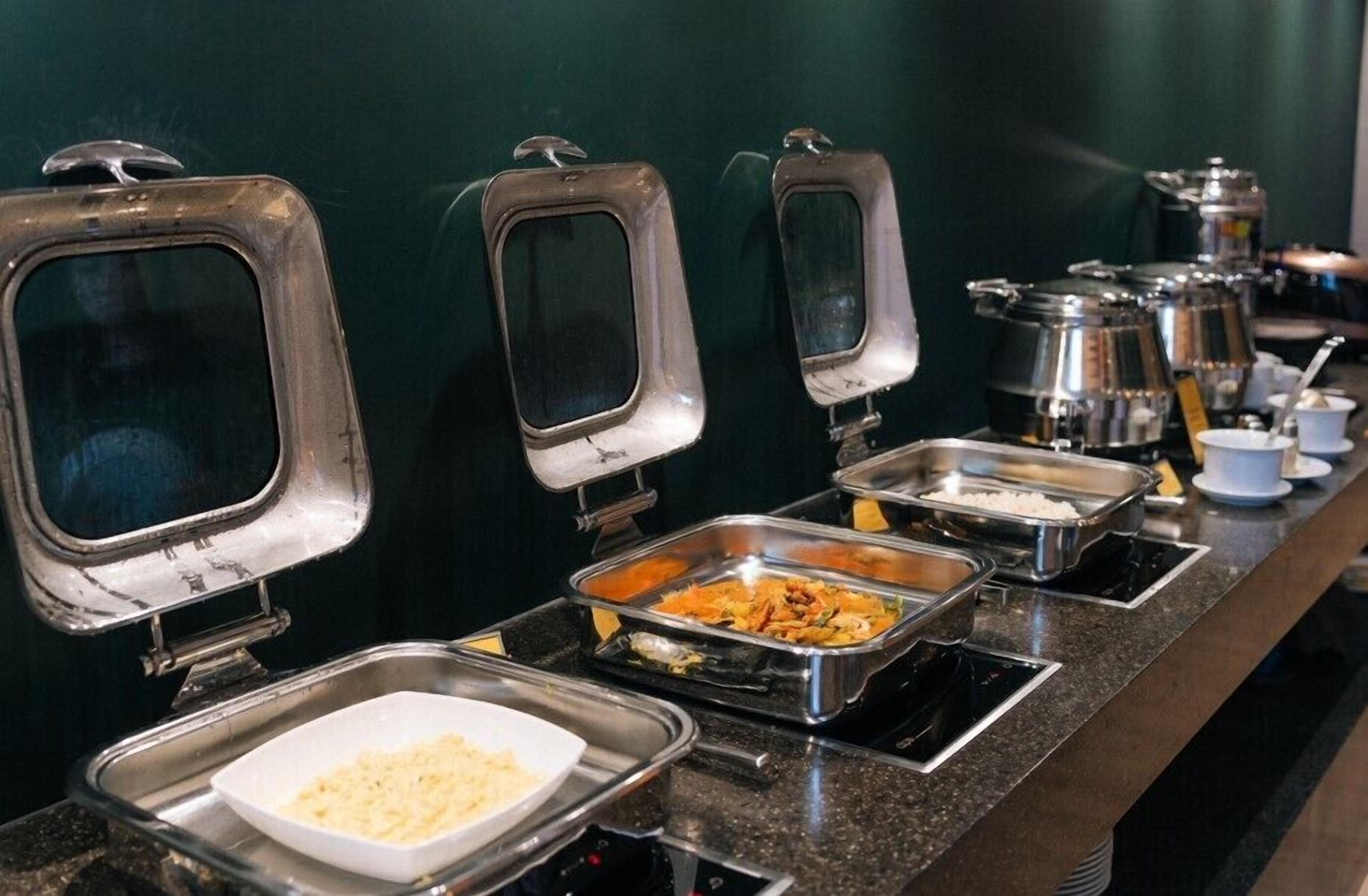 A buffet setup with multiple food stations and serving utensils.