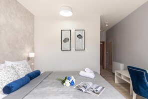 A modern hotel room with a bed, a desk, a chair, and two framed artworks on the wall. - Family Resort Santa Maria II Penthouse (Novalja)