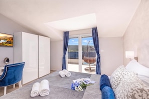 A hotel room with a bed, a chair, a desk, a TV, and a view of the outdoors. - Family Resort Santa Maria II Penthouse (Novalja)