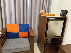 Relax in this cozy space with a comfortable chair and compact table, perfect for unwinding. Enjoy a refreshing drink from the in-room coffee maker and keep essentials chilled in the mini fridge.