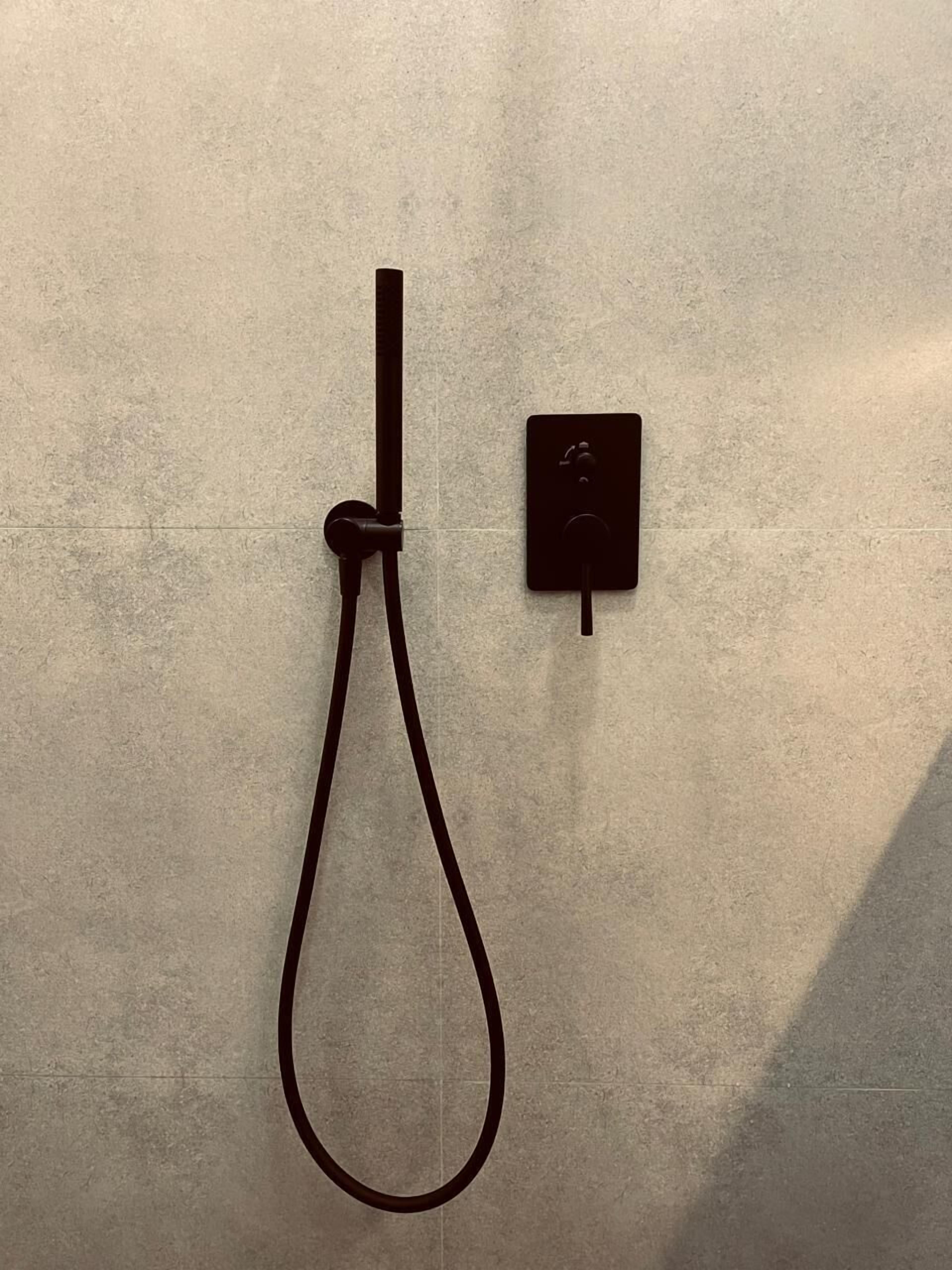 A towel rack with a towel hanging on it, mounted on a textured wall.