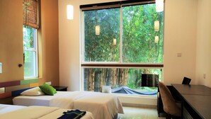 A hotel room with two beds, a desk, and large windows offering a view of greenery. - The Yacht Near CMB-Bandaranaike Intl. (Seeduwa - Katunayake)