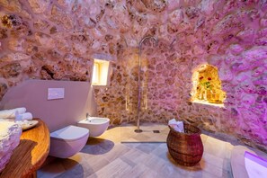A stone-walled bathroom with a sink, toilet, and a shower area. - Lisària Villa Delle Meraviglie with pool (Castrignano de' Greci)