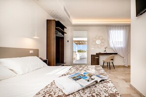 A hotel room with a bed, a desk, a chair, and a view of the outside. - Lisària Villa Delle Meraviglie with pool (Castrignano de' Greci)