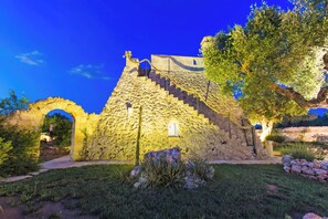 A stone building with a staircase, an archway, and a tree in the foreground. - Tenuta Bouganville With Garden And Pool (Carpignano Salentino)