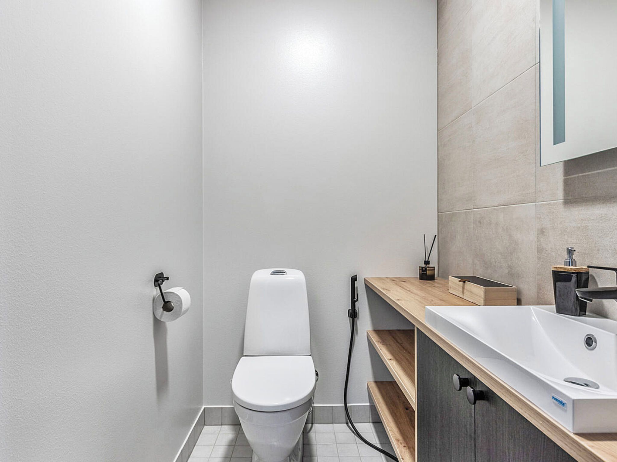 Une salle de bain moderne avec des toilettes, un lavabo et un miroir.