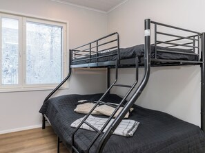 A bunk bed with a ladder, a window with blinds, and a wooden floor. - Villa aava by Interhome (Nilsiä)