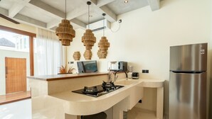 A modern kitchen with a central island, stainless steel appliances, and a large refrigerator. - Liminal Palace Villa 2 by Betterplace (Canggu)