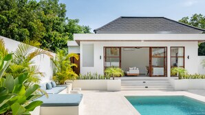 Une maison moderne dotée d’une piscine, d’une terrasse ensoleillée et d’un jardin bien entretenu.