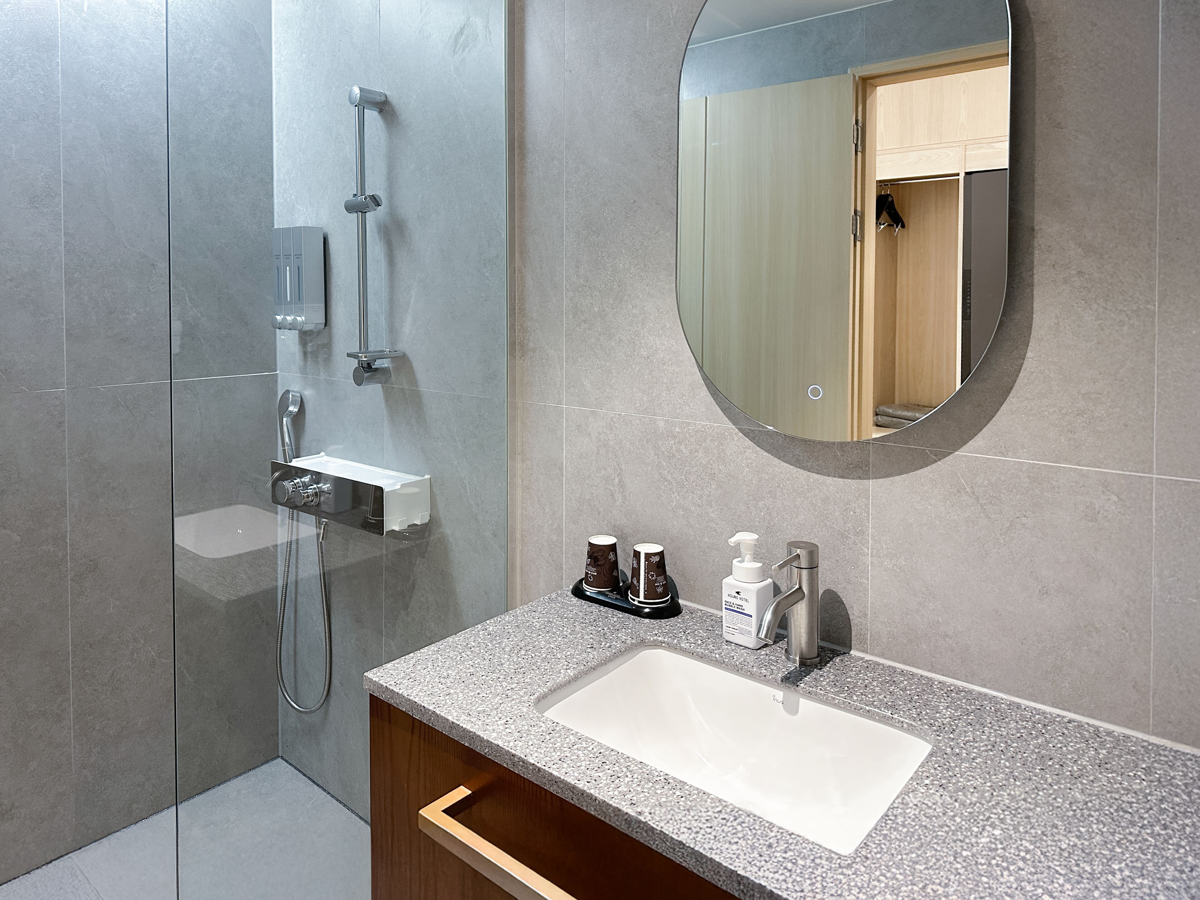 Ein modernes Badezimmer mit Dusche, Waschbecken und Spiegel.