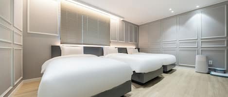 A modern bedroom with two beds, a large window with blinds, and a built-in air purifier.