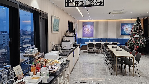 Een restaurantgedeelte in een hotel, met een buffet, een kerstboom en een bordje dat de locatie van de receptie aangeeft.
