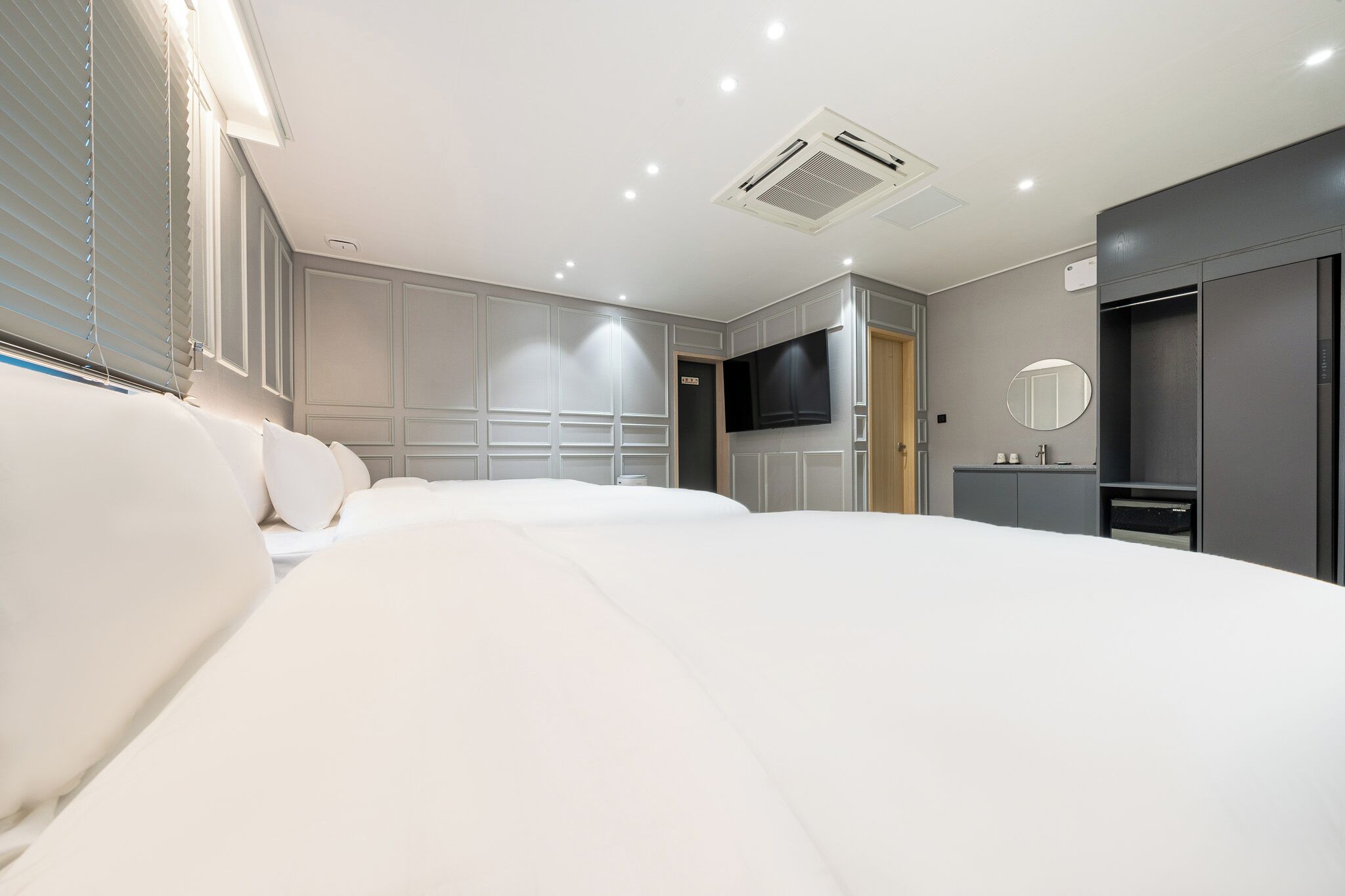 Una habitación de hotel con una cama grande, televisión, armario y baño.