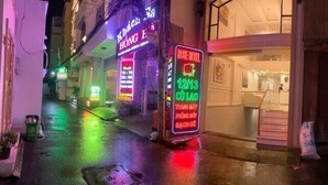 A hotel with a neon sign, a visible staircase, and a closed shop on the right. - Rose Hotel - by Bay Luxury (Ho Chi Minh City)
