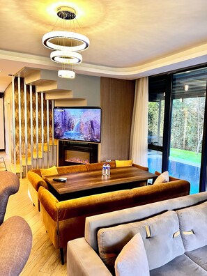 Villa exclusiva | Área de sala de estar | Smart TV de 140 cm con canales vía satélite y chimenea 