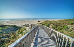 A wooden boardwalk leading to a beach with a clear sky. - Sweet King Studio • Beach Boardwalk + Pool Access + Pickleball | Beach Bliss (Port Aransas)