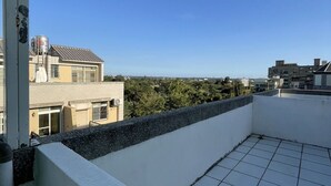 A rooftop terrace with a tiled floor and a white wall. - Yilan (Jincheng)