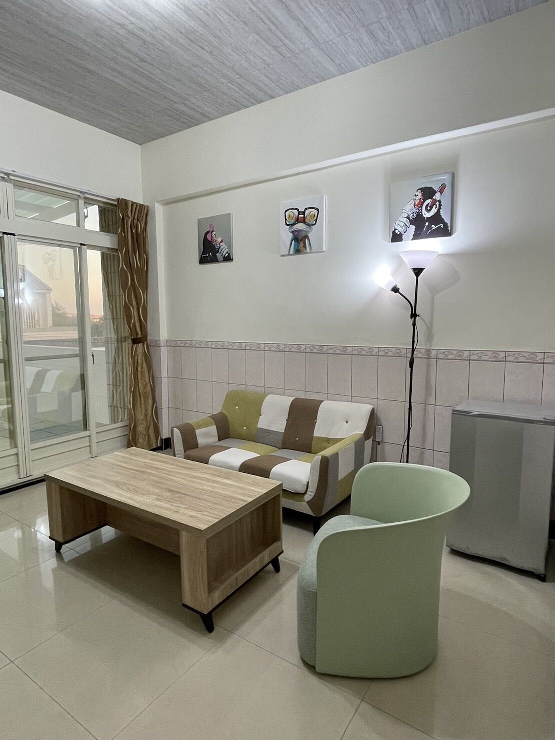 Un salon moderne avec un canapé, une table basse, une lampe et un radiateur.