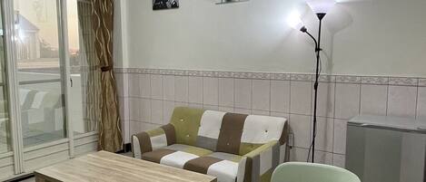 Un salon moderne avec un canapé, une table basse, une lampe et un radiateur.