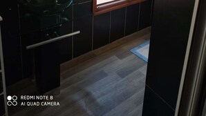 A bathroom with a glass sink, a mirror, and a window with a view of the outside. -  Grace Guesthouse (Antananarivo)