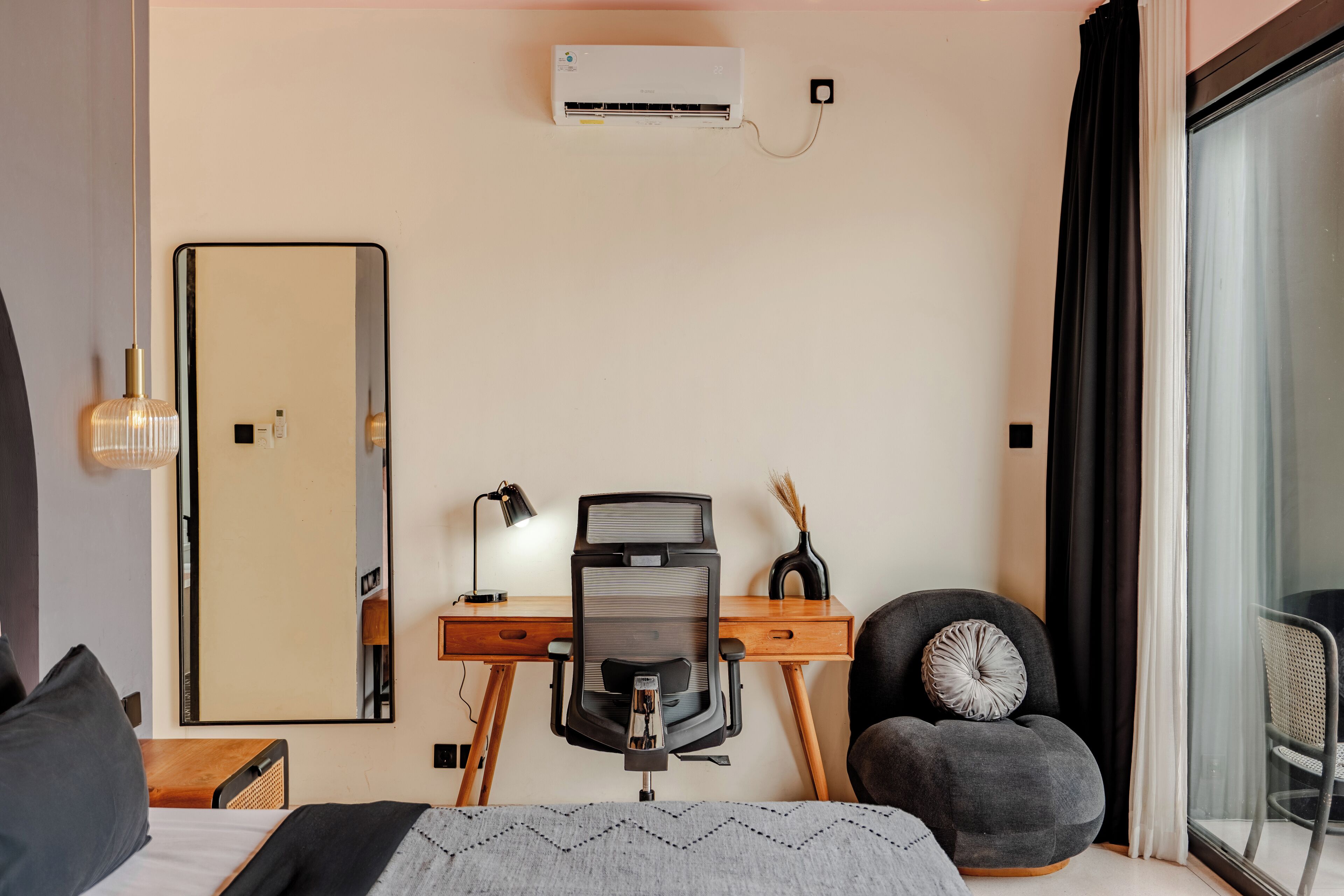 Ein modernes Hotelzimmer mit Schreibtisch, Stuhl und einem großen Spiegel.