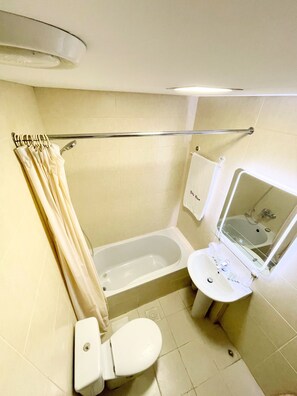 A small bathroom with a toilet, sink, and bathtub.