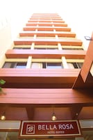 A hotel with a modern design, featuring a staircase leading to the upper floors. The sign indicates it is the Bella Rosa Hotel Suites.