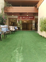 Entrada de un hotel con un cartel que dice "Bella Rosa Hotel Suites".