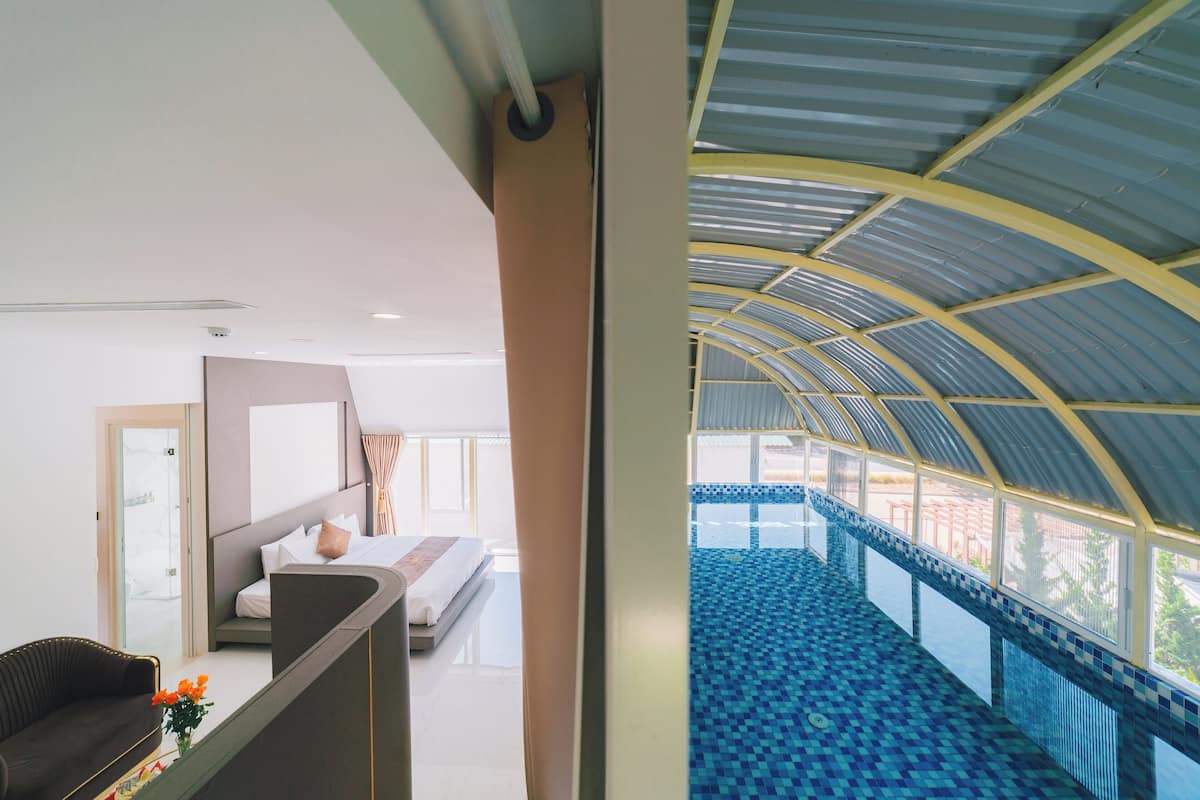 Una habitación de hotel moderna con balcón, cama y zona de estar.
