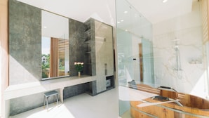 A modern bathroom with a glass enclosure, a wooden bathtub, and a large mirror. - Quy Tai Premium Hotel (Xuan Huong - Da Lat)