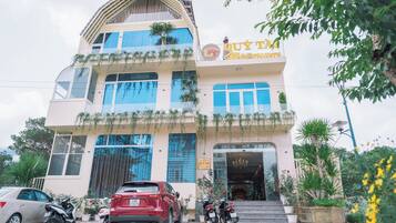A multi-story building with a sign reading "QUY TAI".